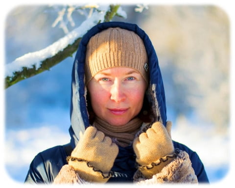 A woman bundled up outdoors on a snowy winter day